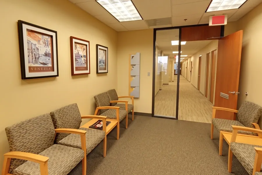 The waiting area outside the treatment rooms, with upholstered chairs and framed prints.